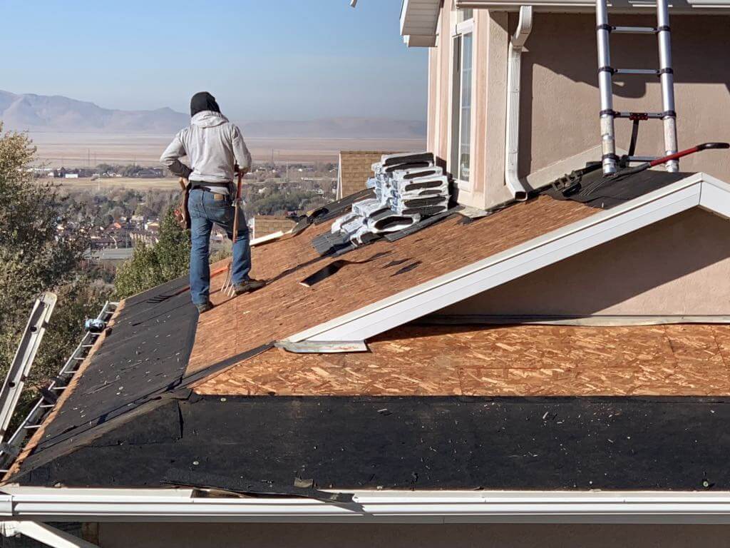 professional roofer installing a roof in Utah, with mountains in the background.