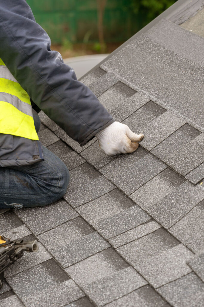 Workman install tile on roof of new house under construction